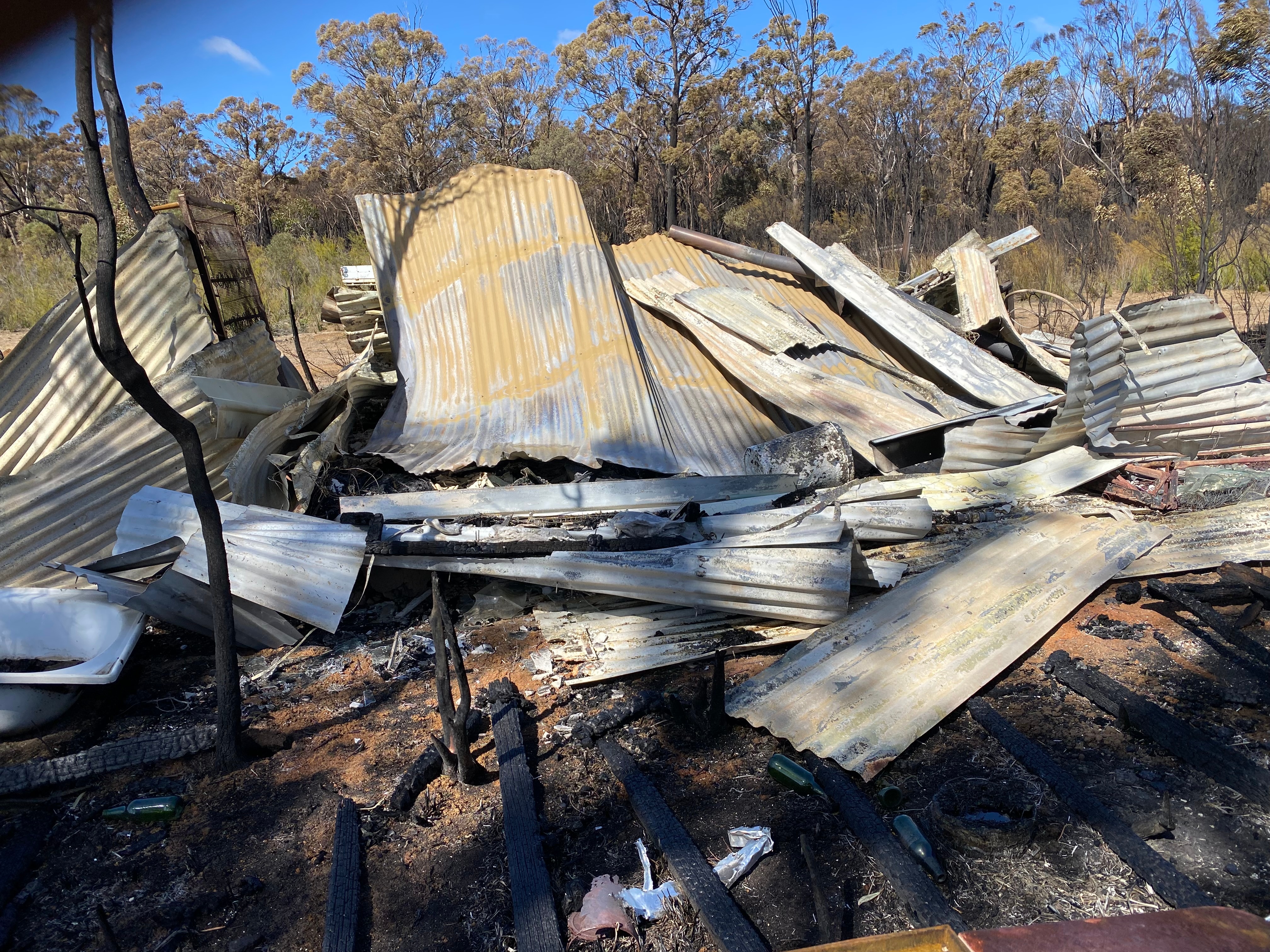 Sheets of rusty tin lie on the ground