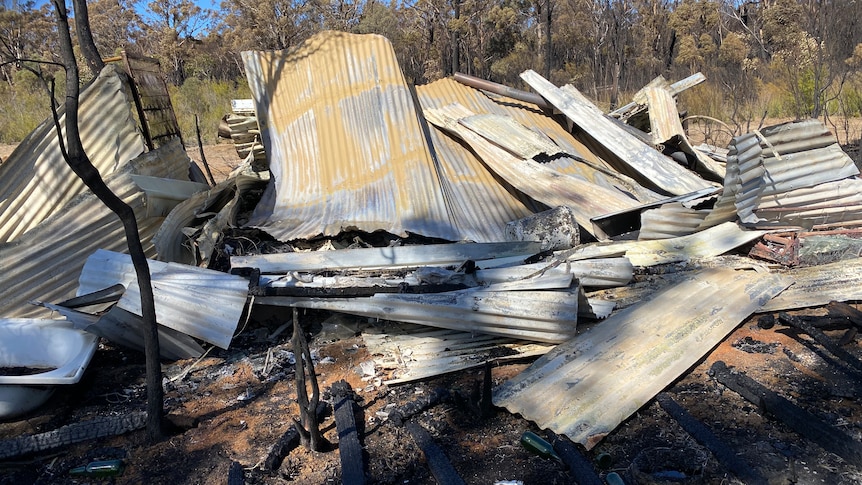 Sheets of rusty tin lie on the ground