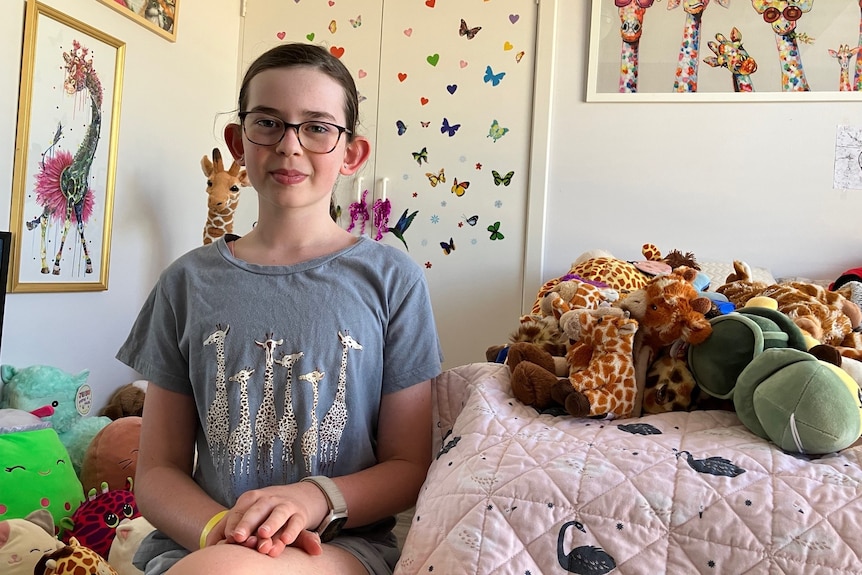 A young girl sitting in her colourful bedroom