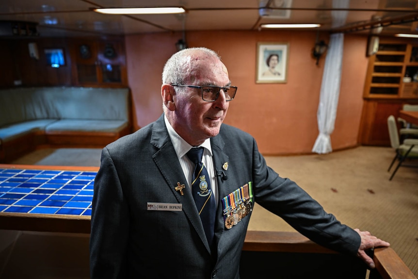 An older man walking through a retired warship