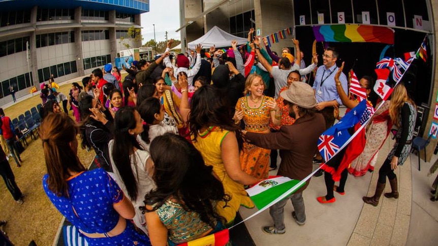 Students from SCU International dancing aside a ring of flags
