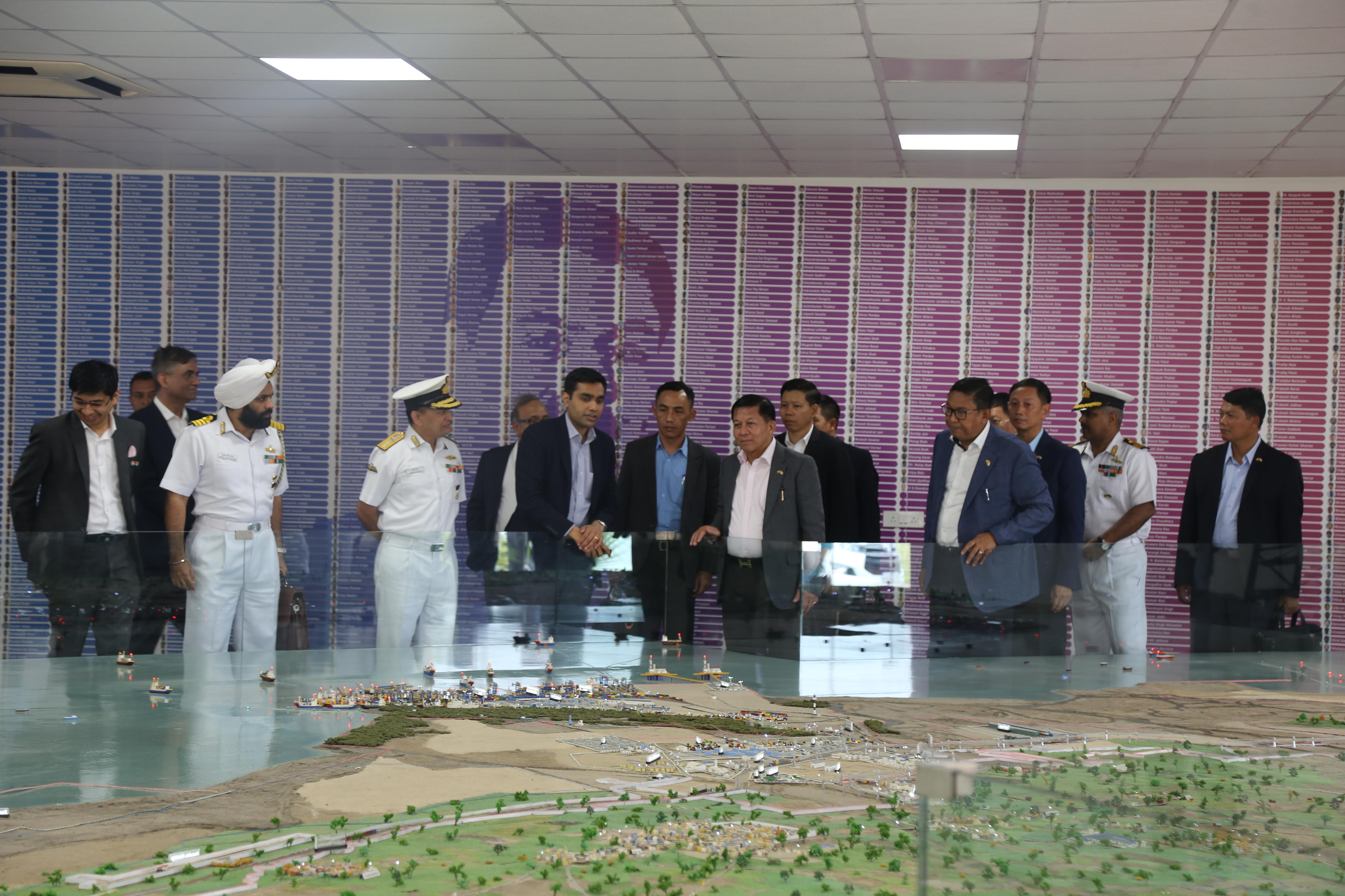 A group of men stand around a table.