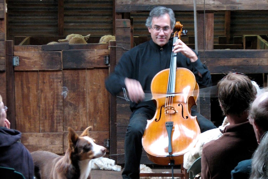 A photo of Michael Goldschlager performing in a sheep barn.
