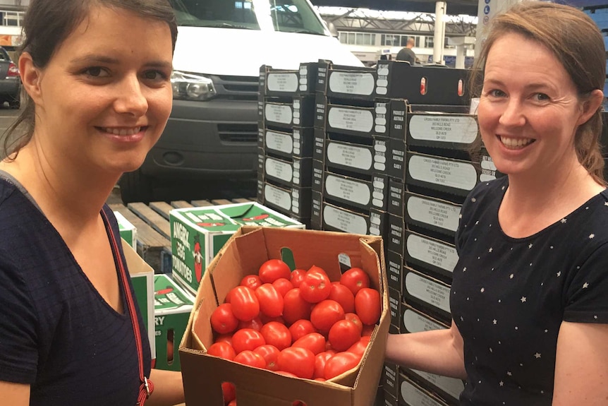 Katja Goodlet and Rebecca Davies hold a box of tomatoes.