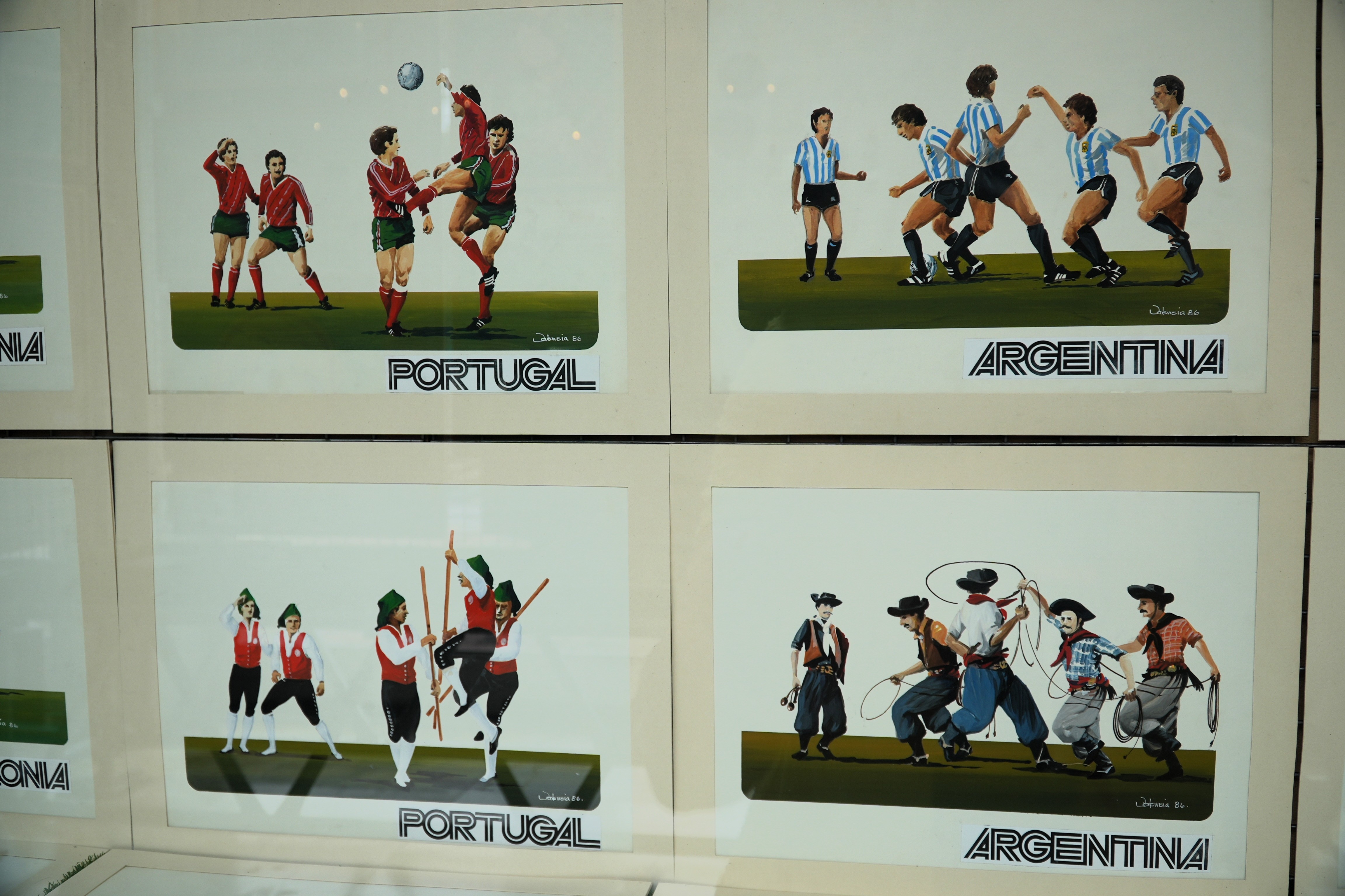Posters depicting Portugal and Argentina cartoon figures playing football, then in traditional dress