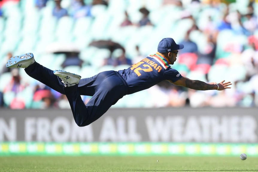 An Indian male cricketer dives in the air as he attempts to take a catch against Australia in Sydney.