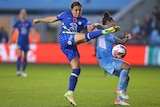 Sam Kerr, playing for Chelsea, shoots the ball around Manchester City defender Demi Stokes.