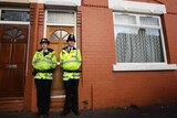 Police stand outside a house in Galsworthy Avenue, Manchester.