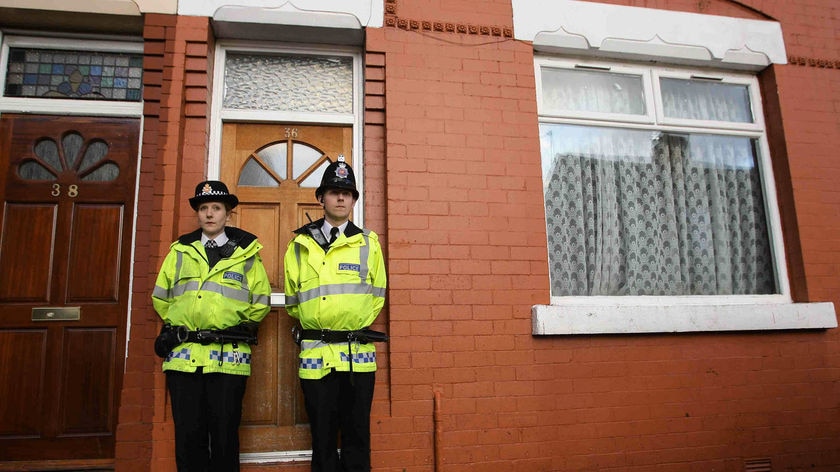 Police stand outside a house in Galsworthy Avenue, Manchester.