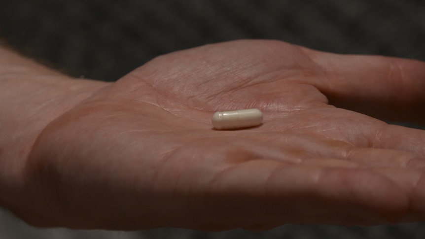 A small pill on an open palm.