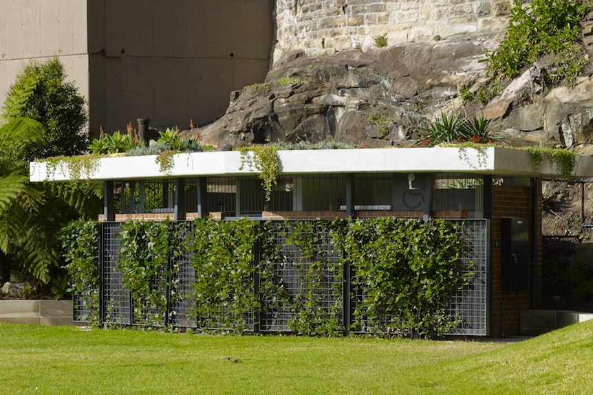 A public toilet block covered in plants