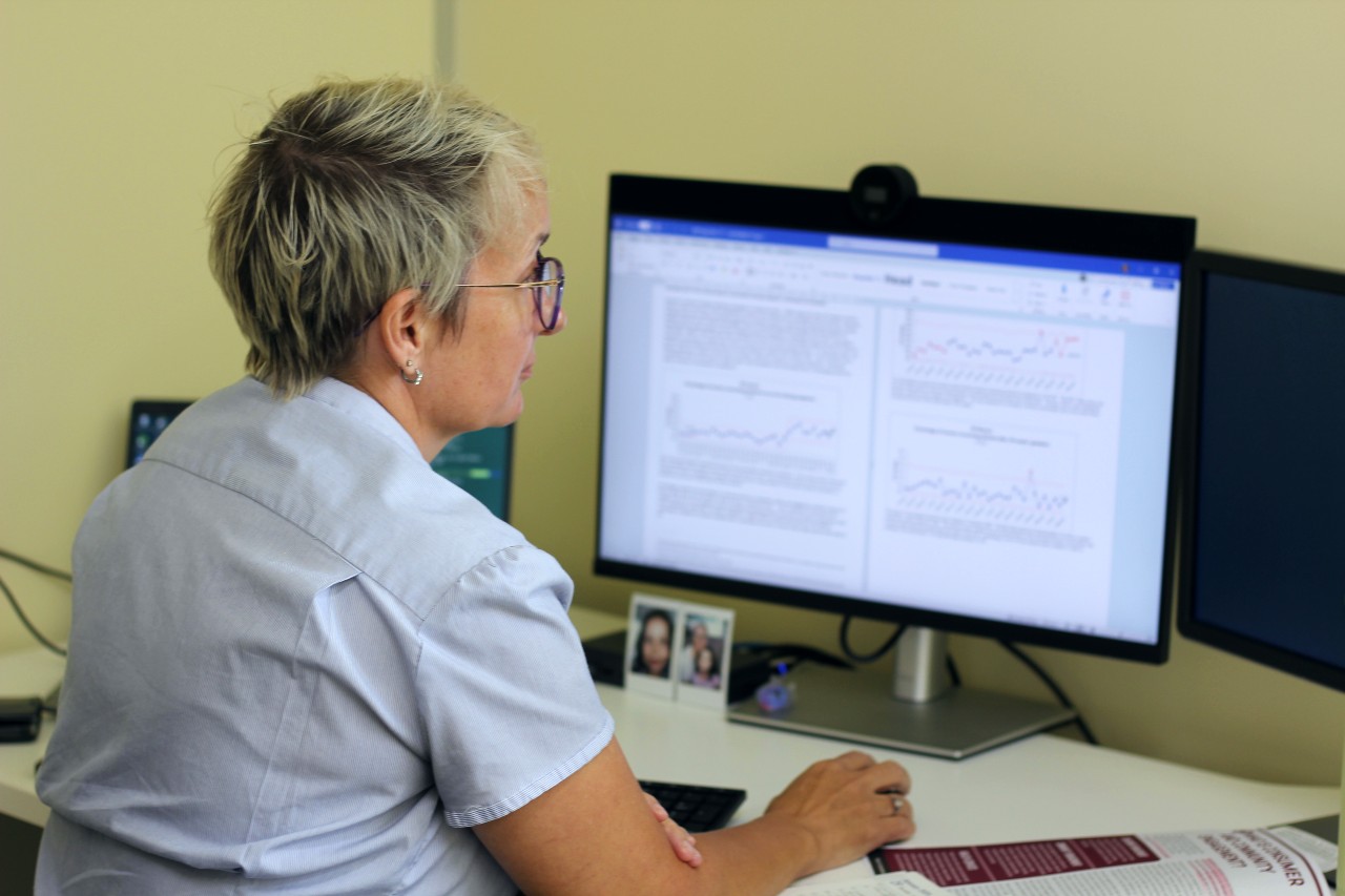 Una mujer con cabello rubio corto y puntiagudo frente a una pantalla de computadora