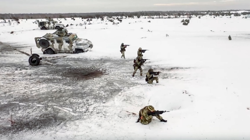 In the snow, Russian soldiers perform drills in an unspecified location in Belarus