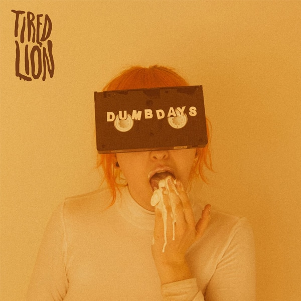 The album art for Tired Lion's debut album Dumb Days, featuring a woman eating icecream with a VHS tape attached to her forehead