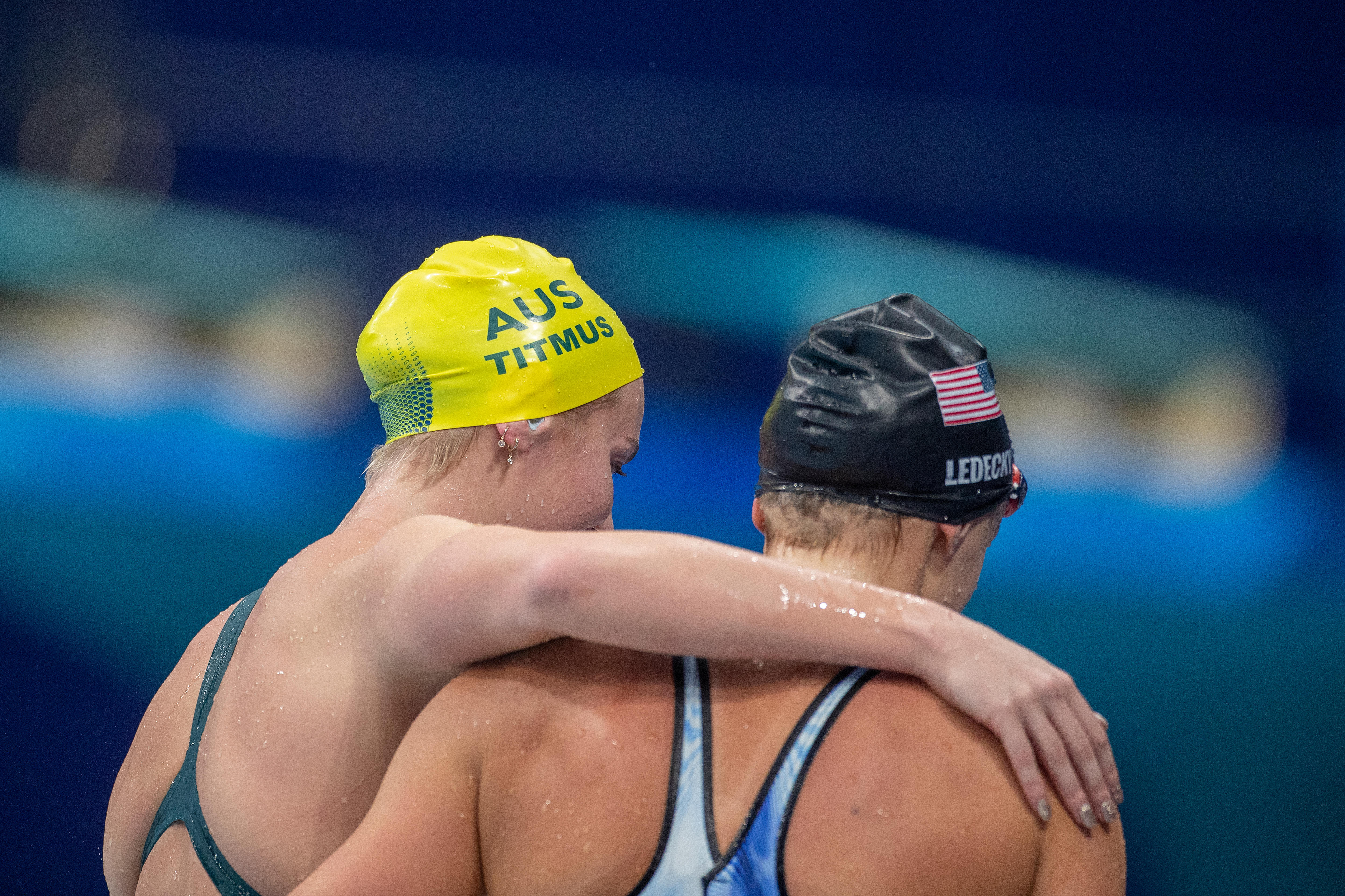Ariarne Titmus and Katie Ledecky hug as shown from behind