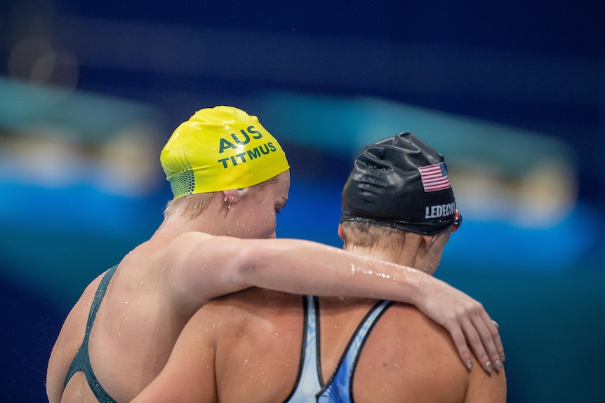 Ariarne Titmus and Katie Ledecky hug as shown from behind