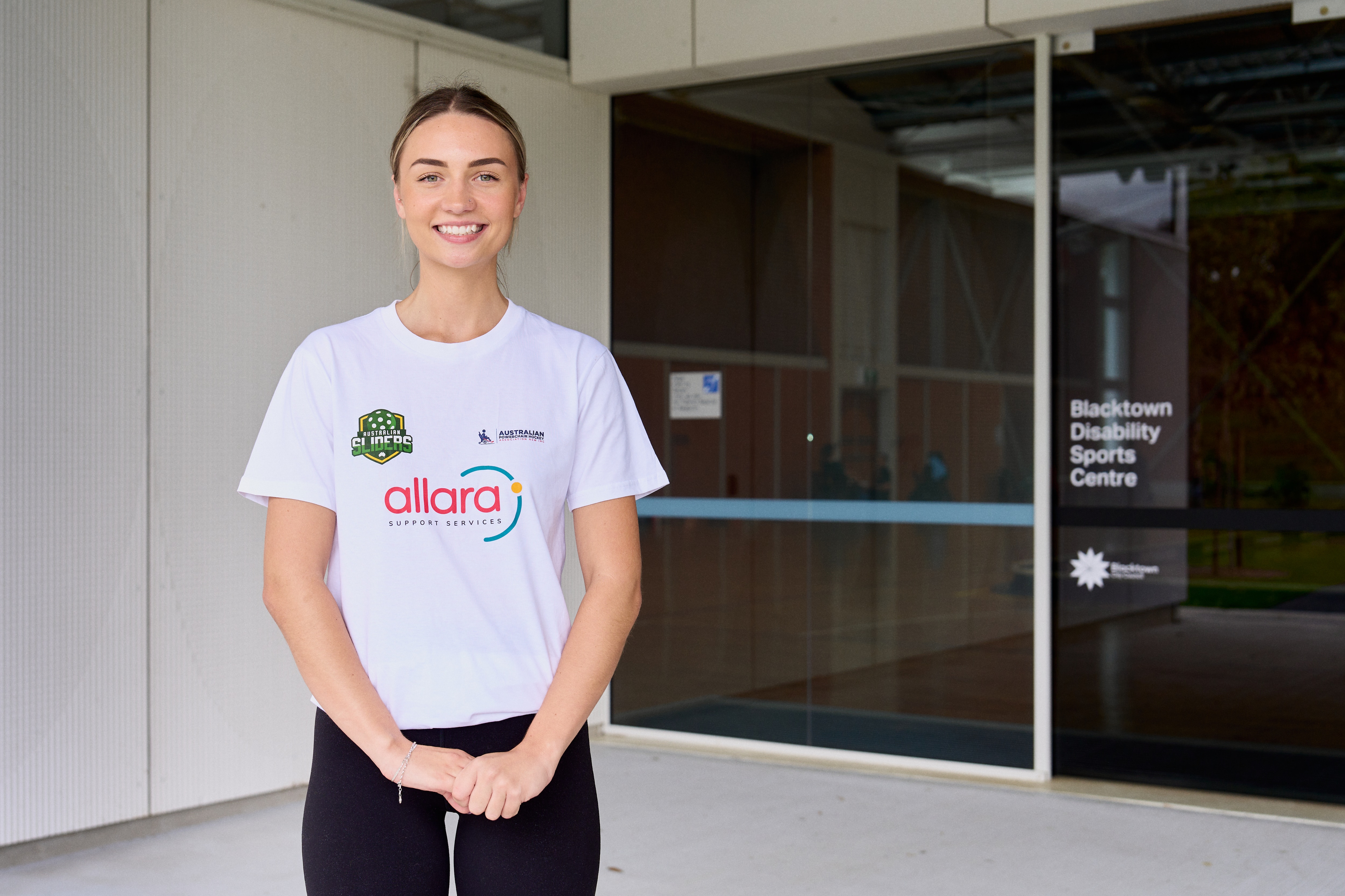 Rachel Willmer em um top branco e rabo de cavalo ao ar livre