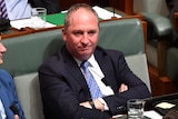 Barnaby Joyce sitting in the House of Representatives with his arms crossed.