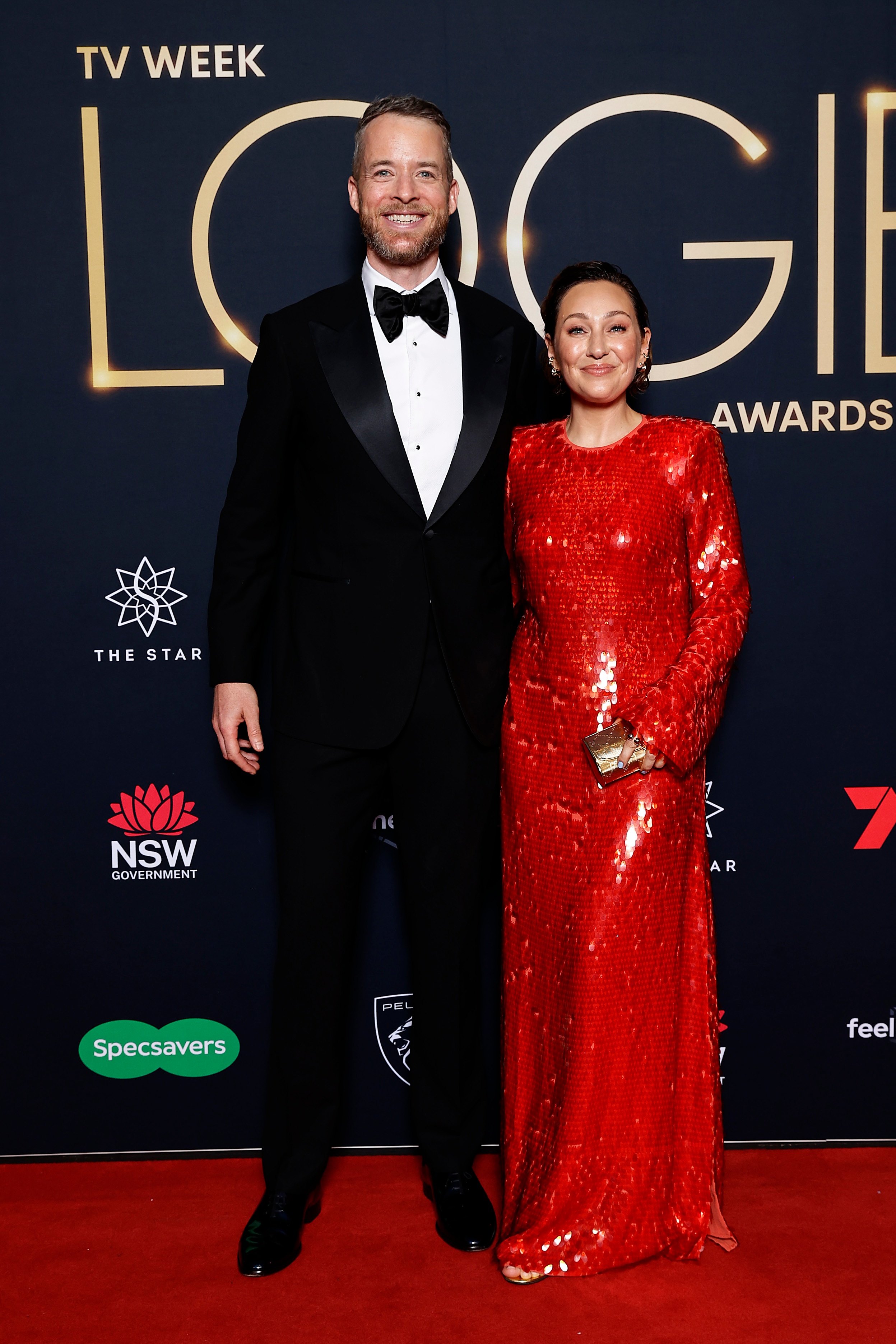 A man and woman, man in a tuxedo and woman in a long red dress