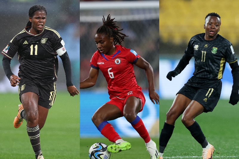 Three black women footballers wearing national team uniforms during a major tournament