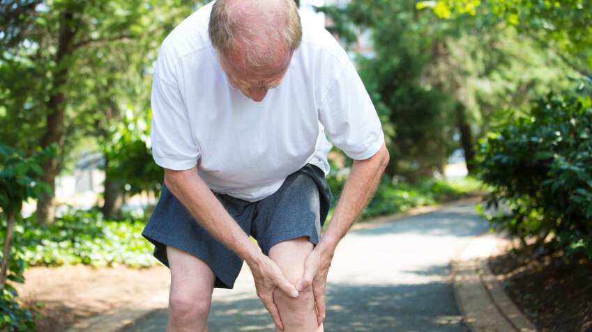 Senior man bent over with knee pain