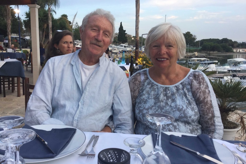 A couple sitting at a table at an outdoor restaurant.