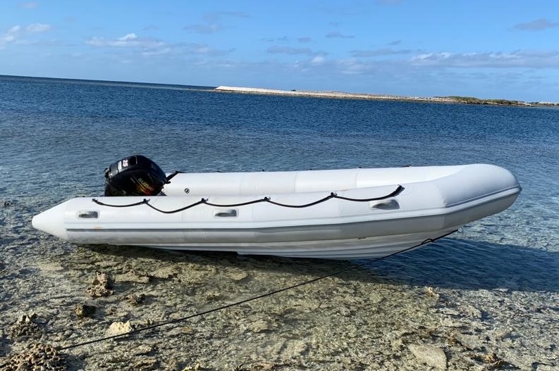 A white dinghy moored in shallow water in the Abrolhos Islands