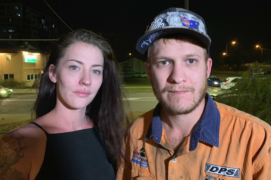 A couple stand outside a motel