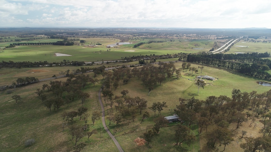 View from a drone across green fields with full dams.