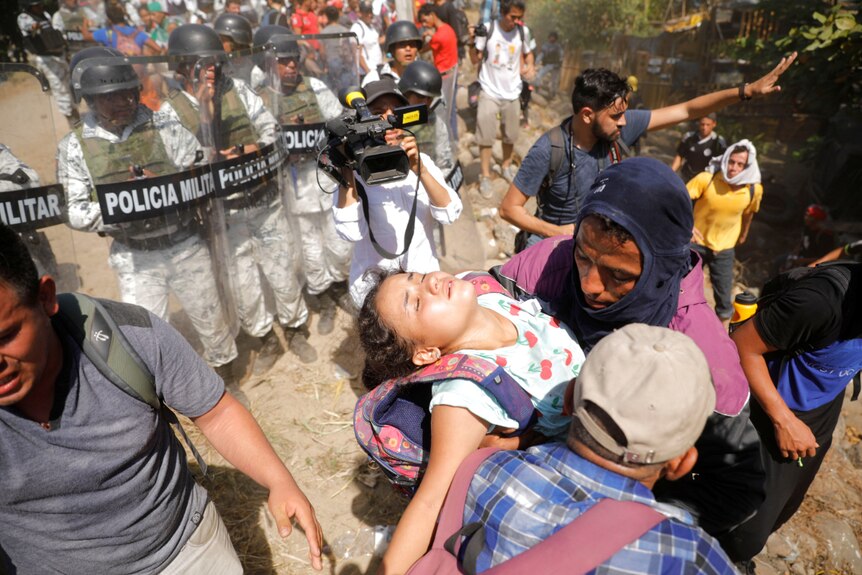 Migrants carry girl