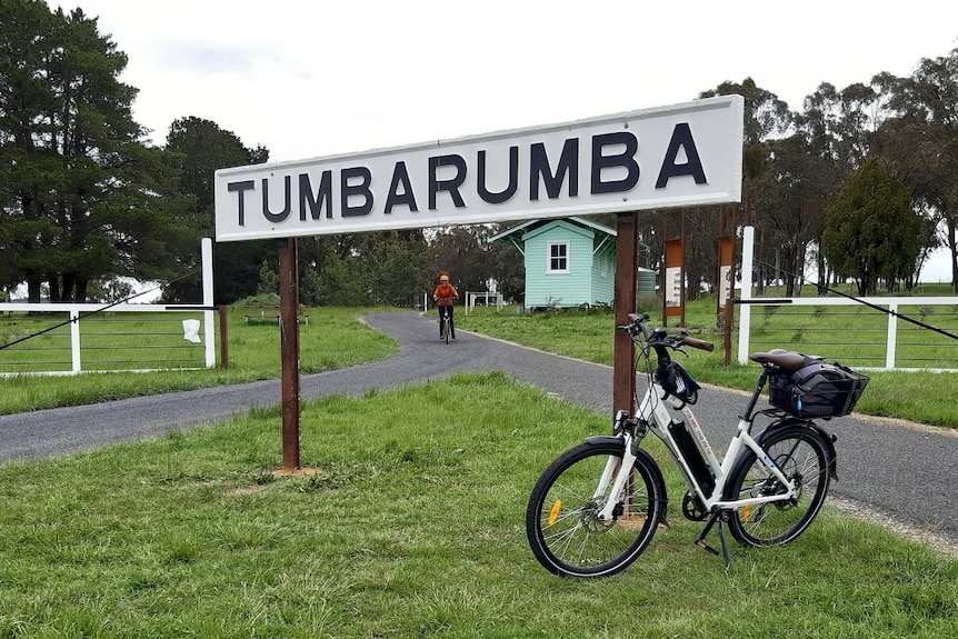A bike leaning against a tumbarumba sign