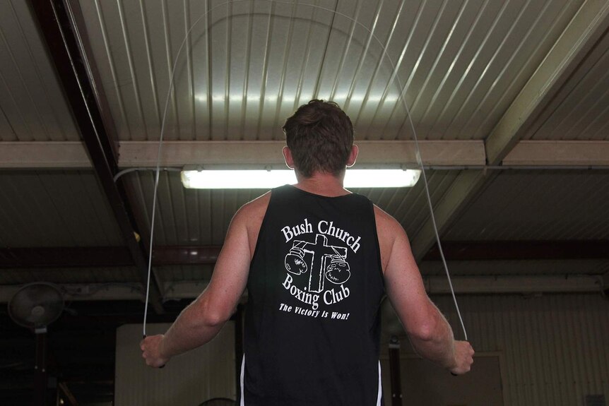 A photo of Bush Church Boxing Club trainer Ketch Crook skipping beneath a fluorescent light.