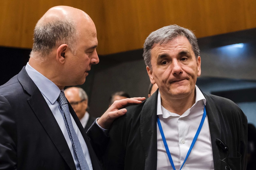 European Commissioner for Economy Pierre Moscovici (left), speaks with Greek Finance Minister Euclid Tsakalotos (right).