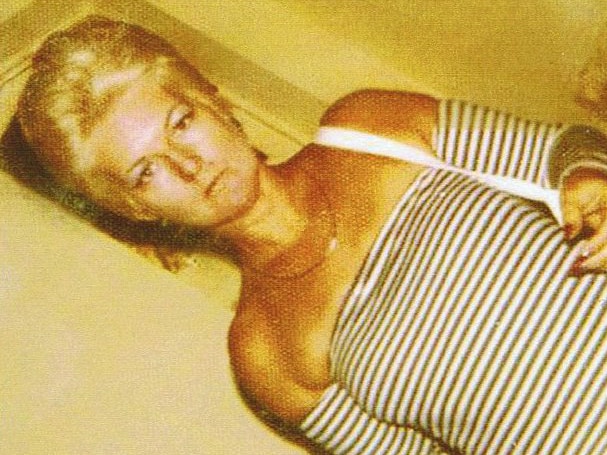 An angled shot of murdered Perth brothel madam Shirley Finn standing wearing a black and white striped top.