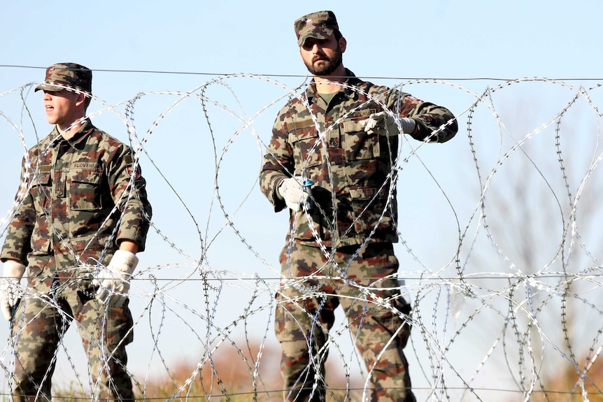 Slovenian soldiers set up barbed wire fences