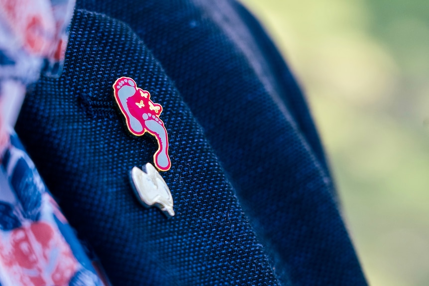 A close up of a pin with the logo for the Small Steps for Hannah foundation