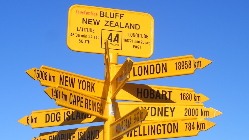 Many yellow signs indicating different cities and distances from Bluff in NZ.