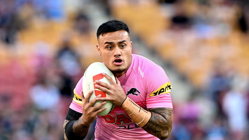 A man runs the ball during a game of rugby league