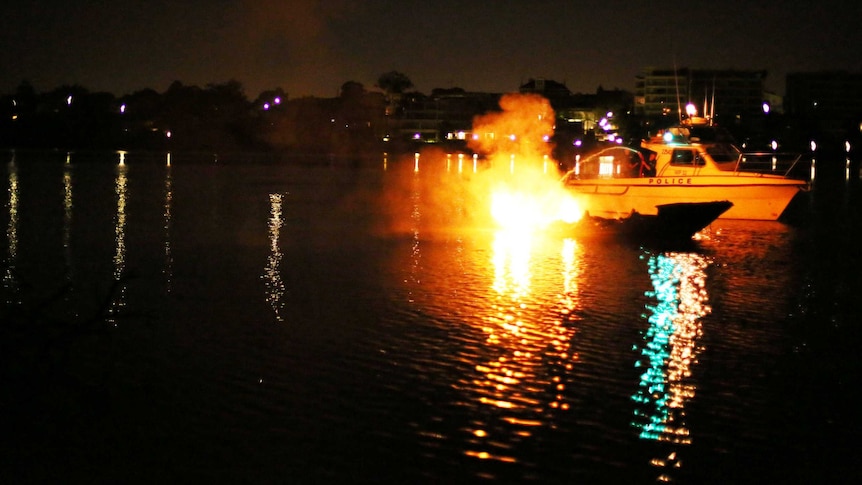 Police attempt to put out a fire that destroyed three luxury yachts in Cabarita, on the Parramatta River, on December 3, 2013.