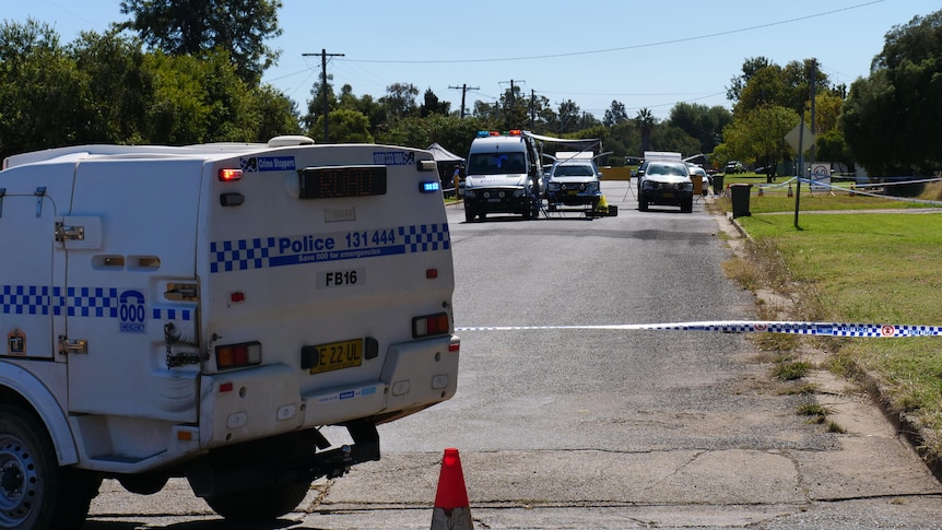 A police car and tape blocking a street