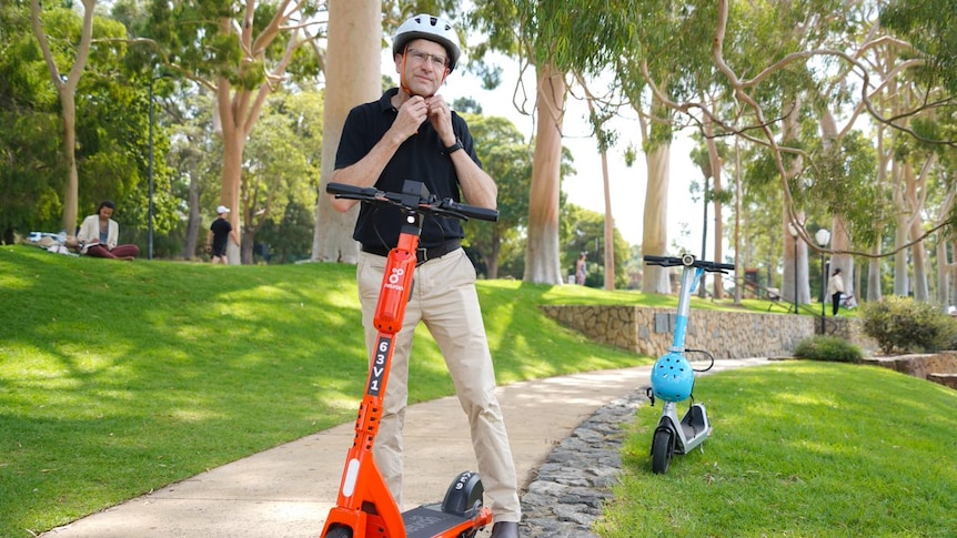  A man wearing a helmet on an e-scooter 