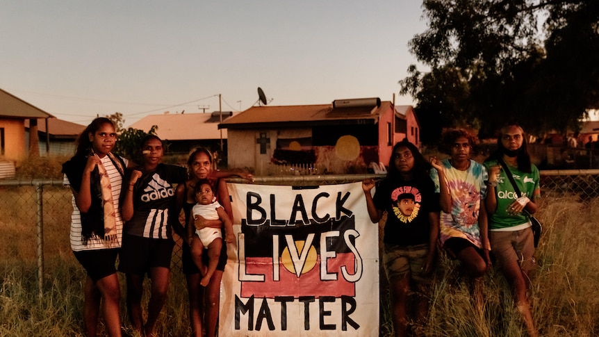 A group of people in the outback holding a Black Lives Matter sign