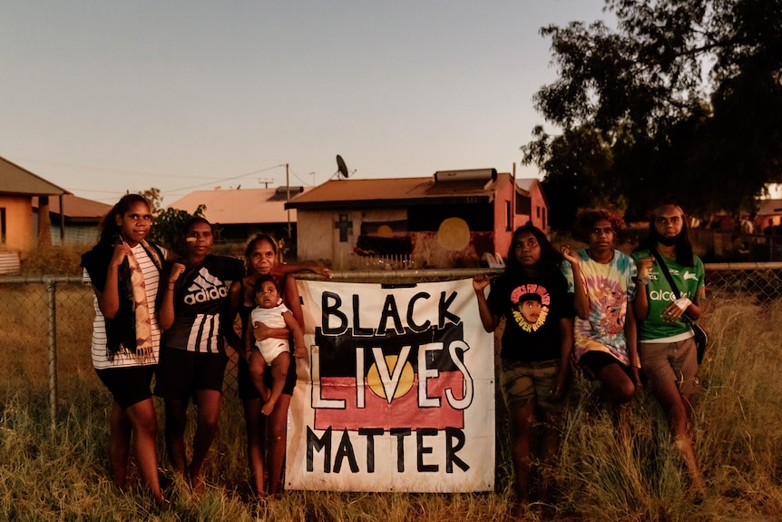 A group of people in the outback holding a Black Lives Matter sign