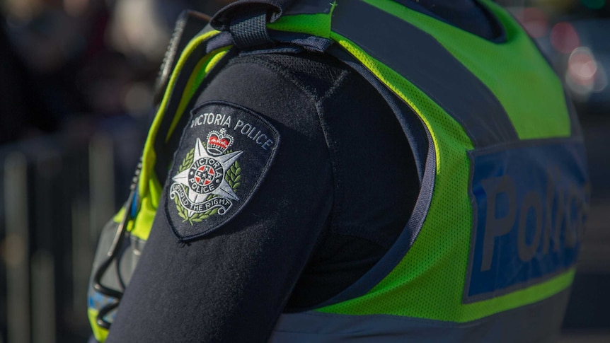 The Victoria Police crest, badge, on the arm of an officer's uniform.