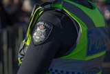 The Victoria Police crest, badge, on the arm of an officer's uniform.