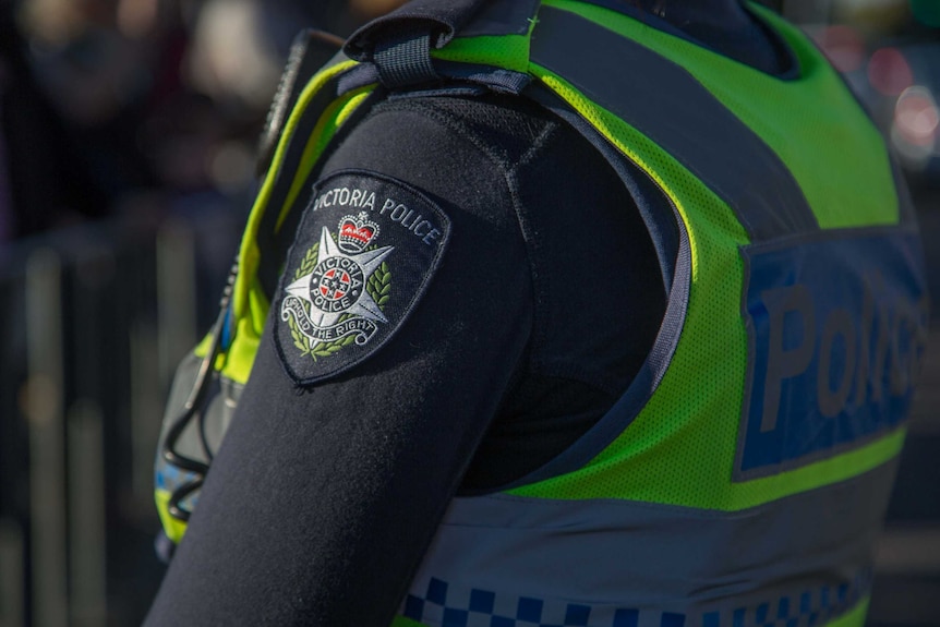 The Victoria Police crest, badge, on the arm of an officer's uniform.