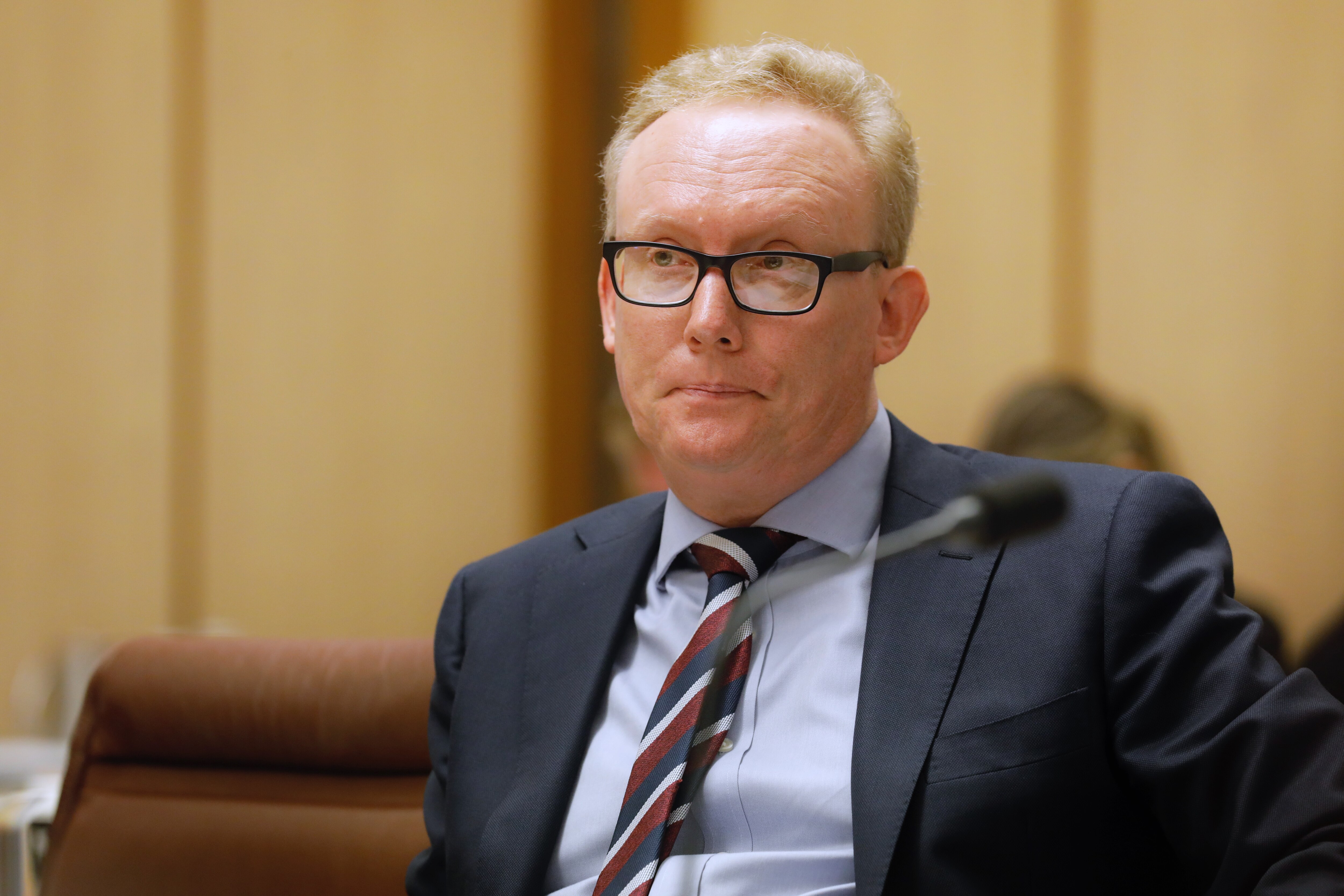 David Hazlehurst sits with pursed lips at estimates