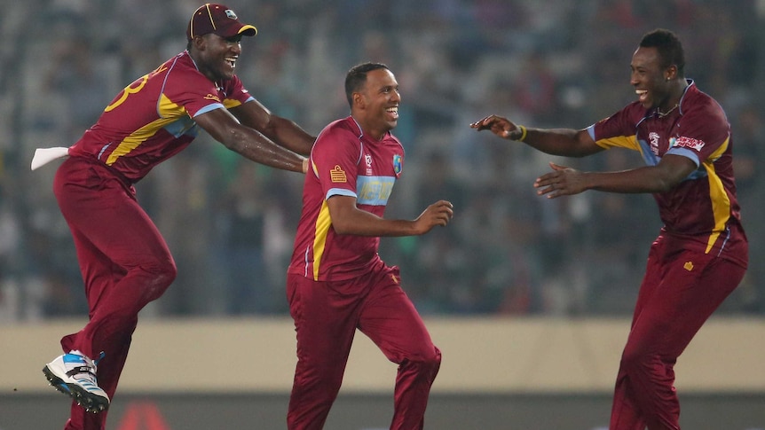 West Indies' Samuel Badree is congratulated by Darren Sammy after taking the wicket of Pakistan's Shoaib Malik