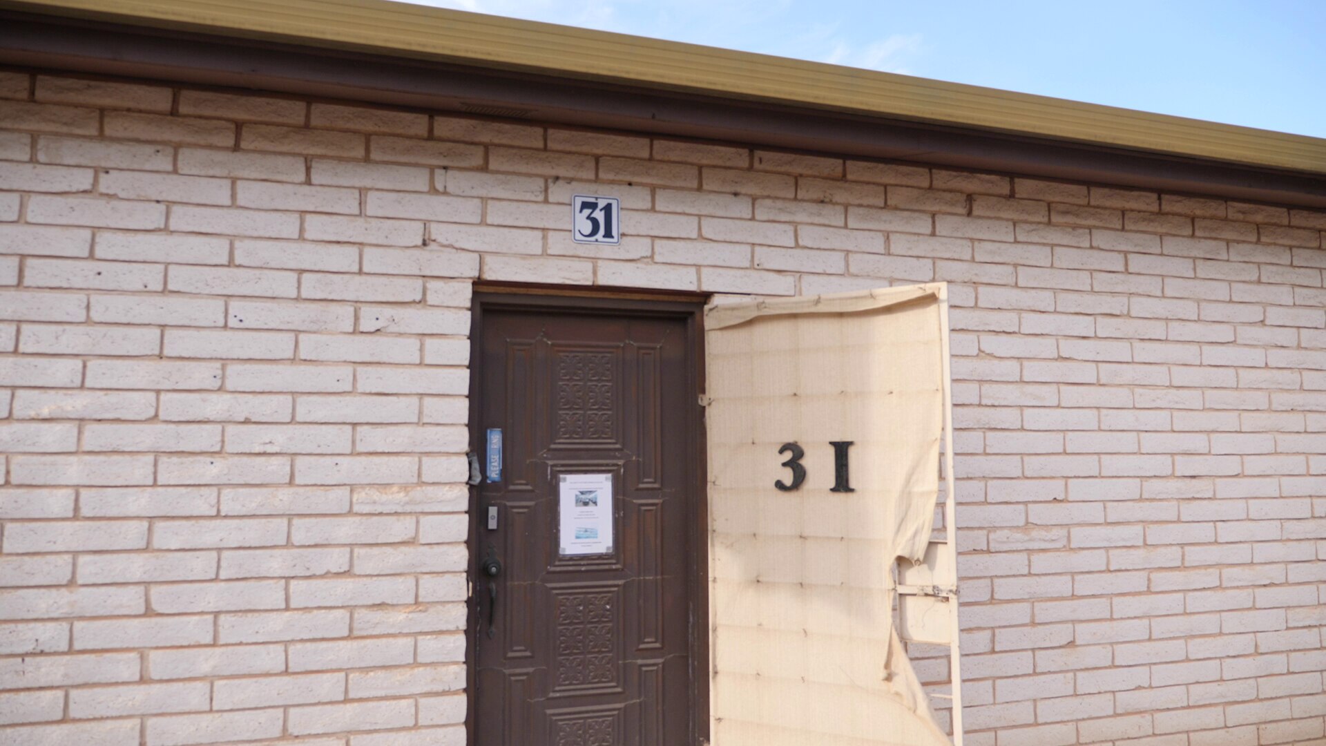 A cream coloured brick building with a wooden door and the number '31' above to signal this is the gallery.