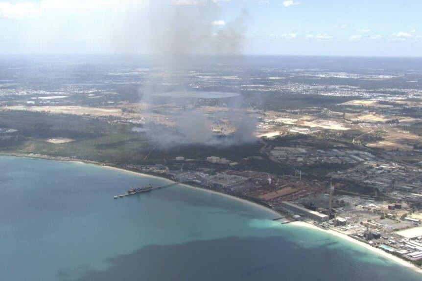 An aerial shot of smoke in an area close to the coast 